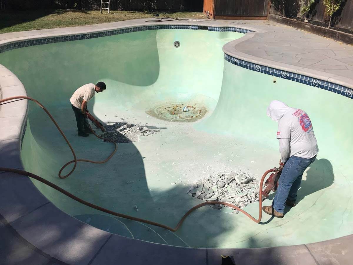 using a jackhammer on a swimming pool removal